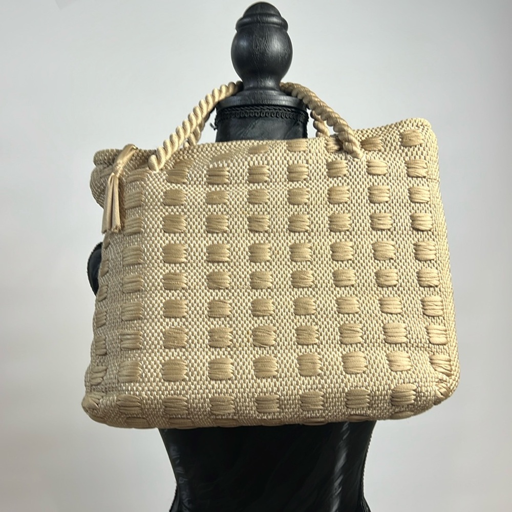 a rectangular tote style made of a woven material in a light beige or tan color.